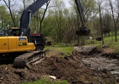 Excavator digging a pond in Earlham, Iowa